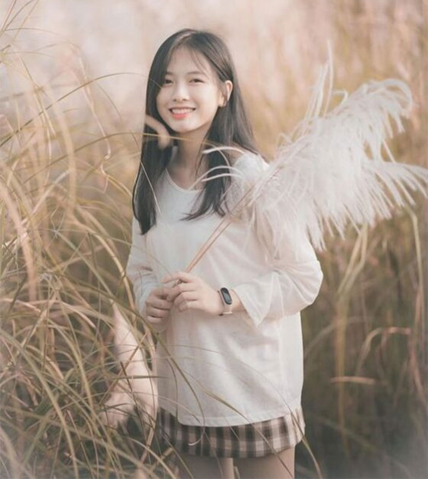 Holding reed grass and smiling brightly